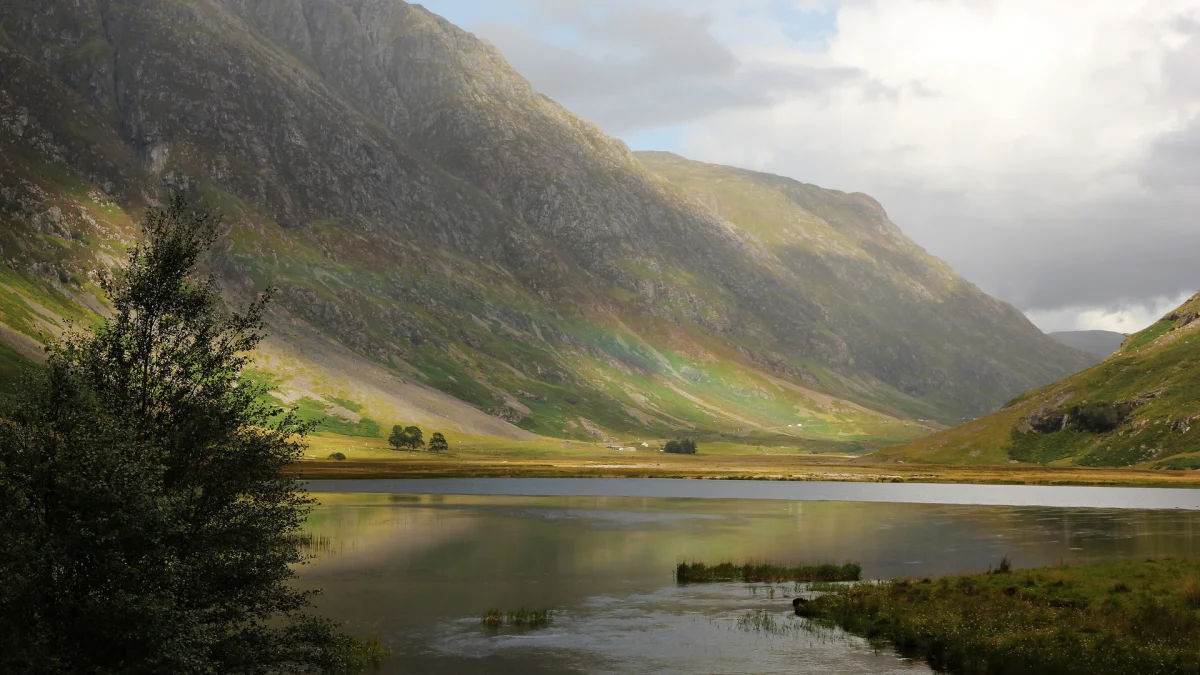 Glenco, a Scottish valley, with a lake beneath a cloudy sky