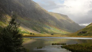 Glenco, a Scottish valley, with a lake beneath a cloudy sky