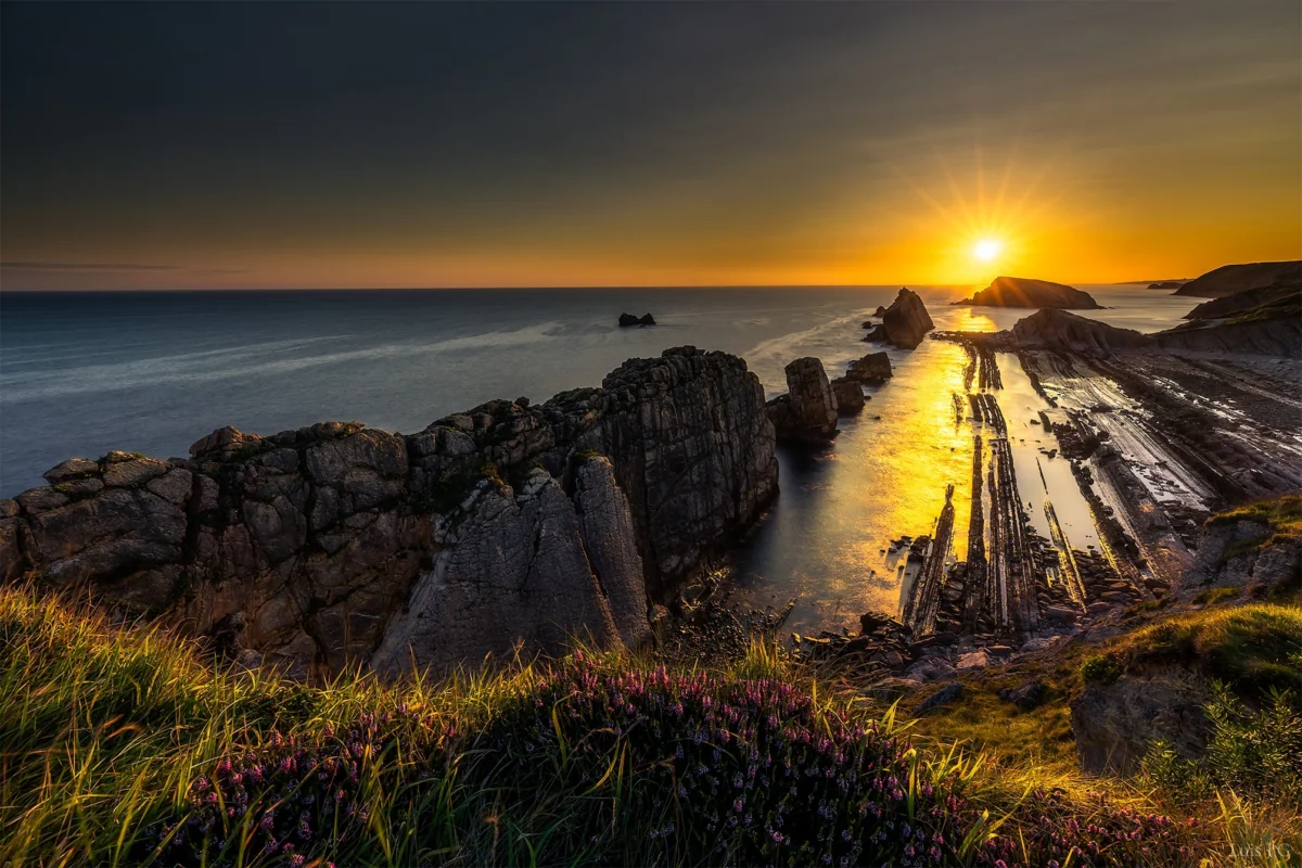 A golden sunset over Spain's rocky coastline