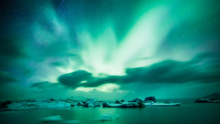 a green glow over an icy lagoon in iceland, aurora, clouds, glaciers, iceland, lagoons, landscapes, northern lights, polar lights, north-light, north-lights, merry dancers, sky, snow, stars, winter, winters, nature, world