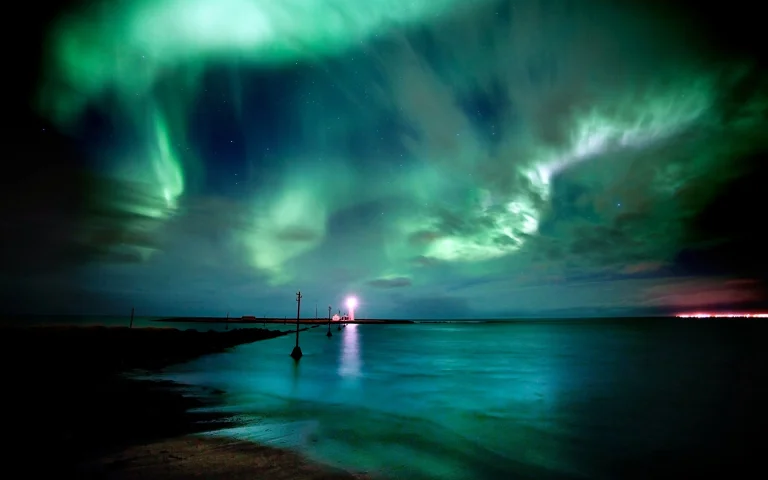 A green glow above an Icelandic lighthouse