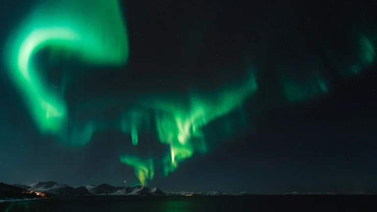 Green flashes over the snow-capped mountains of Norway