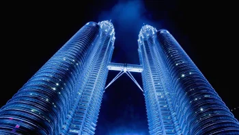 the glowing petronas towers in kuala lumpur at night, petronas towers, malaysia, cities, city, contemporary architecture, night lights, lights, streetlights, street lamps, lighting, night, sky, skyscrapers, architecture