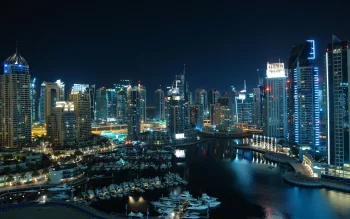 The lights of Dubai Marina at night, with a view of the skyscrapers and yachts
