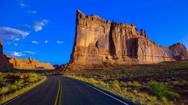 An asphalt road winding through the red rocks of Arches National Park in the United States