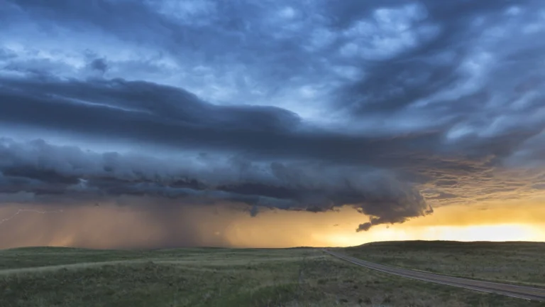 A thunderstorm front over the plains of the United States at sunset