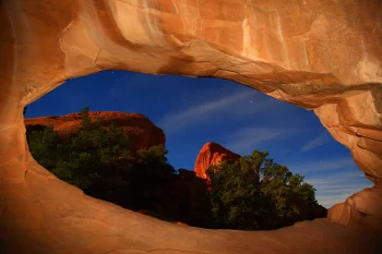 A starry sky framed by the red cliffs of an American canyon