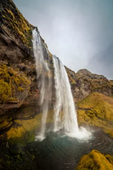 Seljalandsfoss Waterfall in Iceland under a cloudy sky