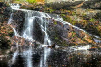 A mountain stream flowing down the rocks in an autumn forest