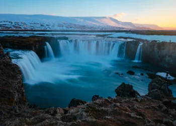 Godafoss Waterfall bathed in the rays of the setting sun in Iceland