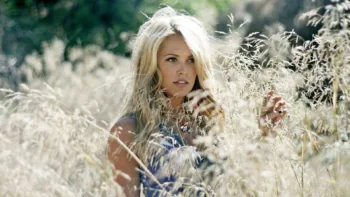 A fair-haired girl in a field of tall grass