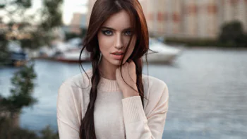 A girl's pensive gaze against the backdrop of the waterfront promenade