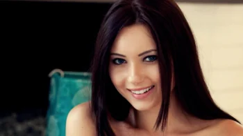 A portrait of a smiling brunette with expressive blue eyes