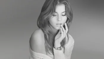 A black-and-white portrait of a young woman in soft light