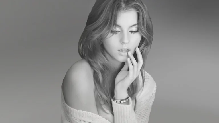 A black-and-white portrait of a young woman in soft light