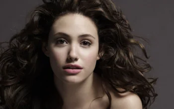 A portrait of Emmy Rossum with voluminous dark curls