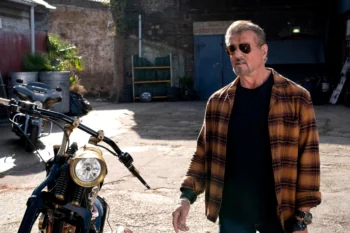 Sylvester Stallone in character, with motorcycles in the background