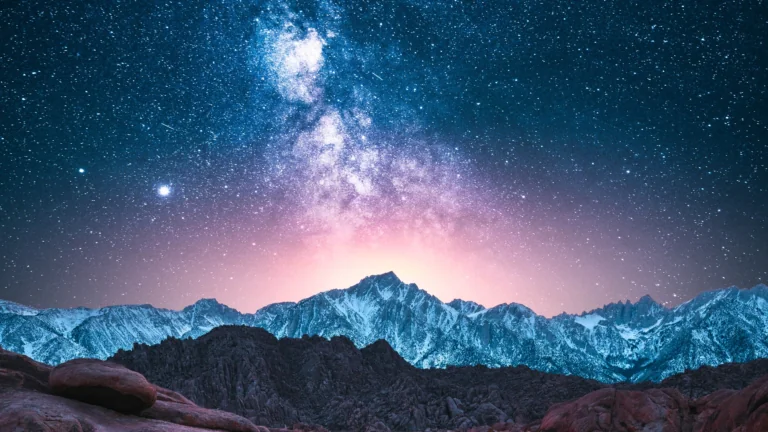 The Milky Way above the snow-capped mountain peaks