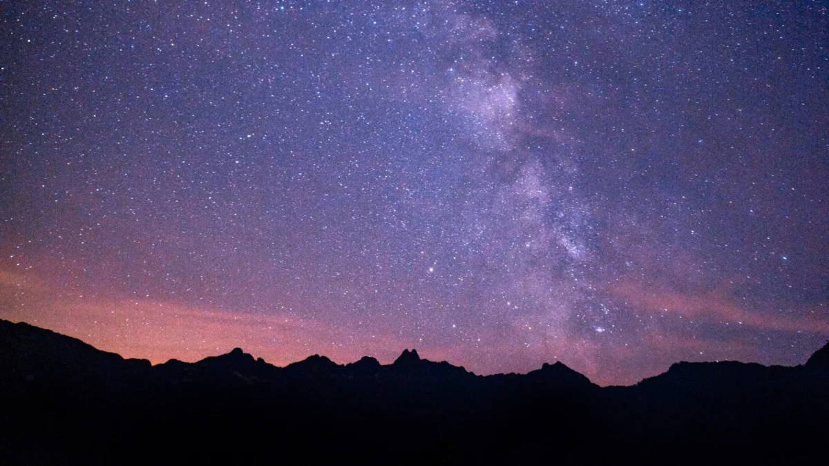 The Milky Way above the dark silhouettes of the mountain ranges