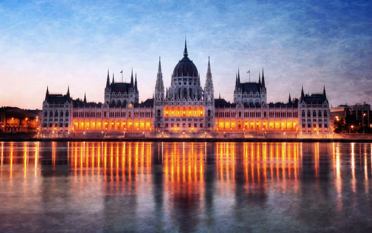 The lights of Parliament at dusk reflected in the Danube