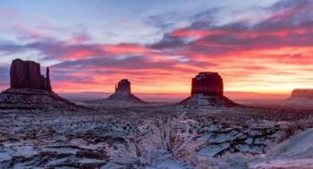 A pink sunset over the snow-covered cliffs of the Valley of the Monuments in the United States