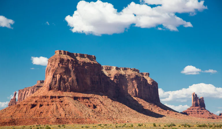 The red cliffs of the Valley of Monuments under a bright blue sky