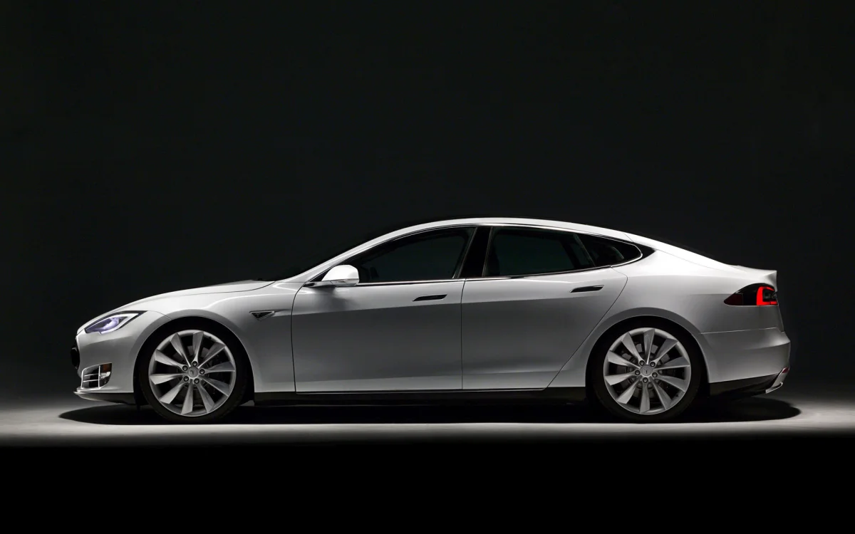Білосніжний седан Tesla Model S у променях студійного світла