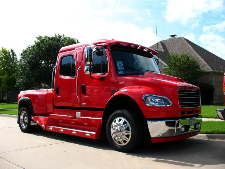 A bright red Freightliner SportChassis on a suburban street