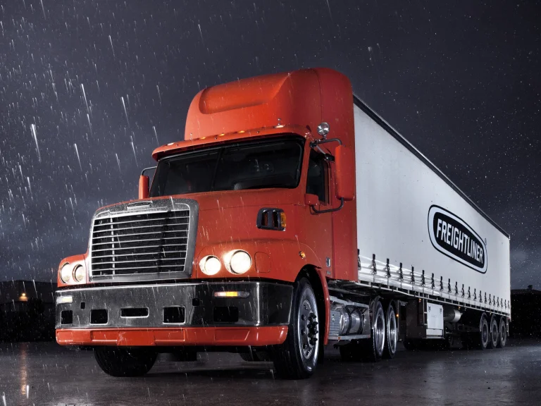 Оранжевый тягач Freightliner под дождем