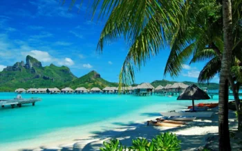 The turquoise waters of the Bora Bora lagoon, with palm trees in the foreground