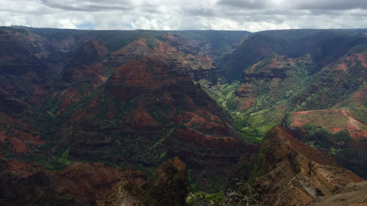 The deep gorges of Waimea Canyon beneath Hawaii's cloudy sky