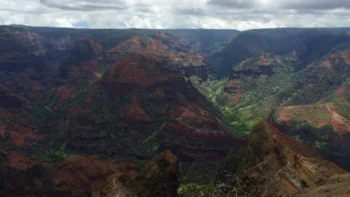 The deep gorges of Waimea Canyon beneath Hawaii's cloudy sky