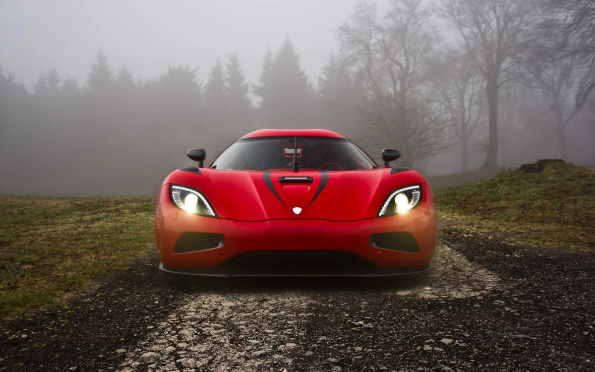 A red Koenigsegg Agera against the backdrop of a misty Swedish forest