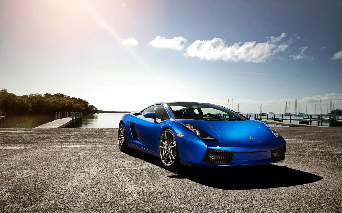 Синяя Lamborghini Gallardo на фоне морского причала