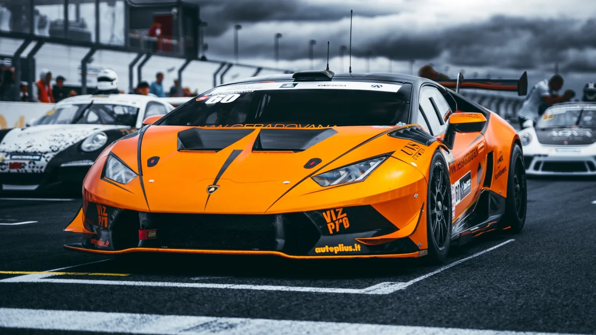 An orange Lamborghini Huracán on the starting grid of a race track