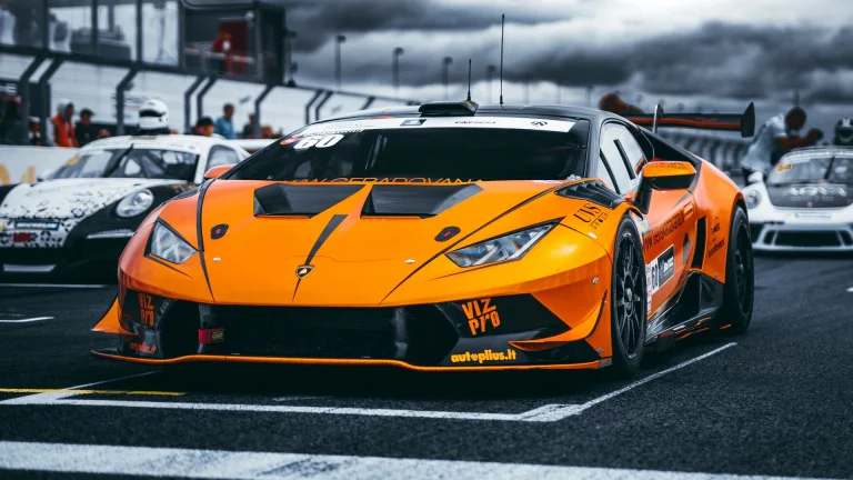 An orange Lamborghini Huracán on the starting grid of a race track