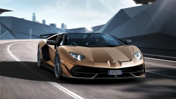 A golden Lamborghini Aventador SVJ on the highway