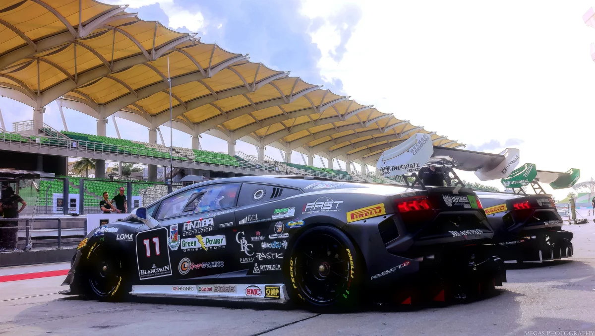 Lamborghini Huracan GT3 race cars in the pit lane under the grandstand canopy