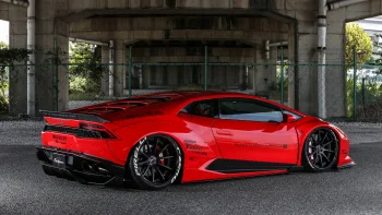 A red Lamborghini Huracan with Liberty Walk body kit under a concrete bridge