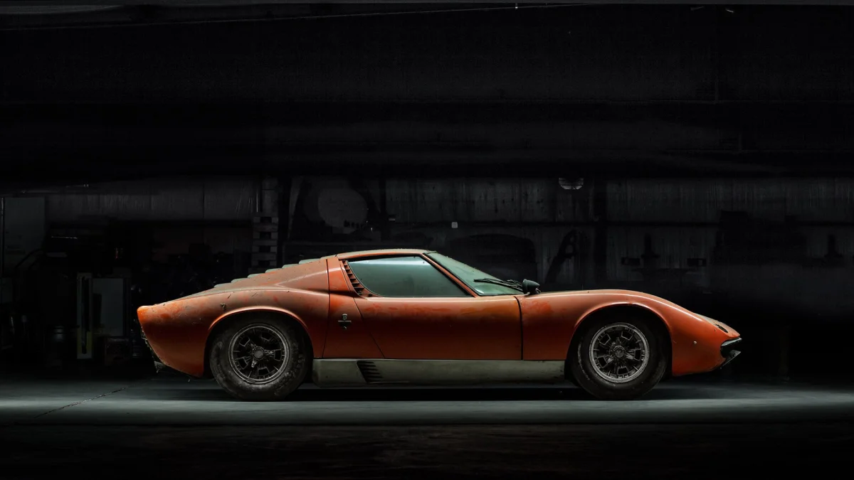 Оранжевая Lamborghini Miura в полумраке гаража