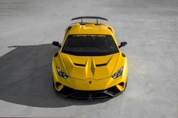 Ярко-желтый Lamborghini Huracan с тюнингом Vorsteiner на бетонной площадке