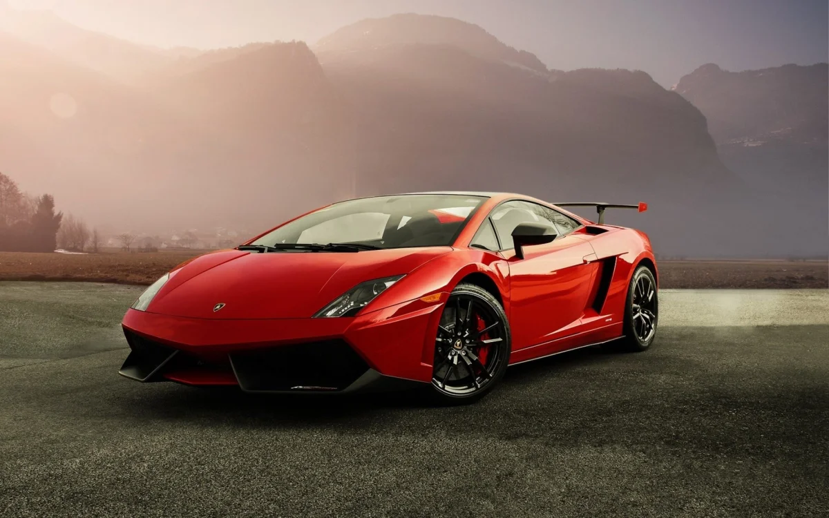 Красная Lamborghini Gallardo на фоне туманных горных вершин
