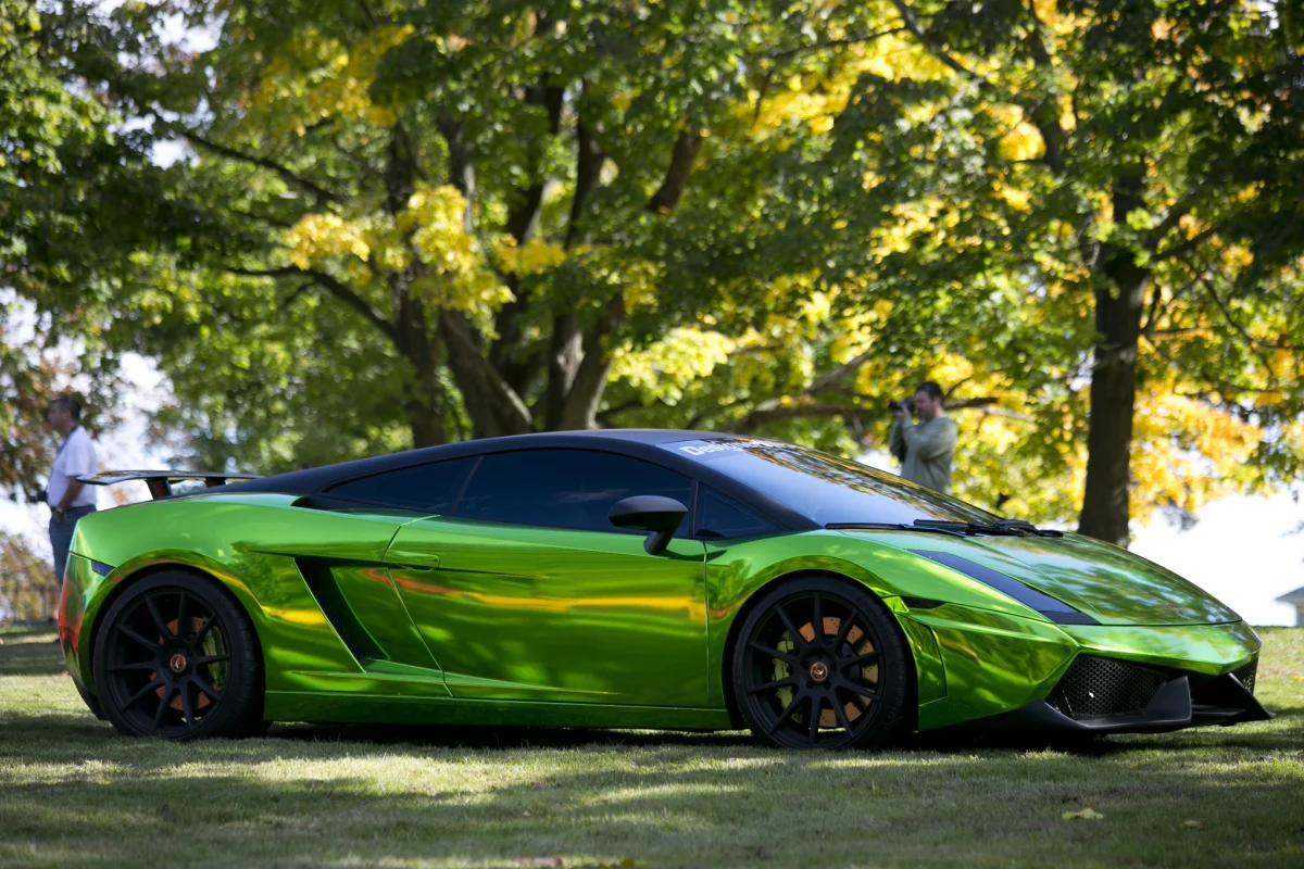 Ярко-зеленая Lamborghini Gallardo на фоне осенней листвы