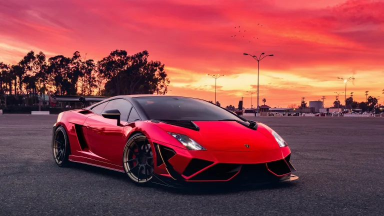 A red Lamborghini Gallardo against the backdrop of a blazing sunset