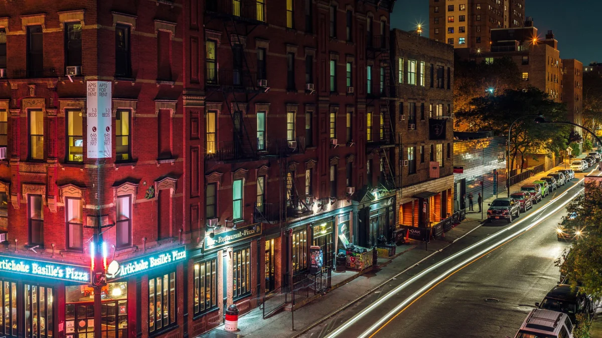 The lights of Manhattan at night, with the facades of brick buildings