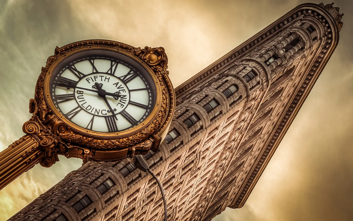 A street clock against the backdrop of the Flatiron Building