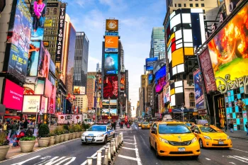 Yellow taxis and a police car in bustling Times Square