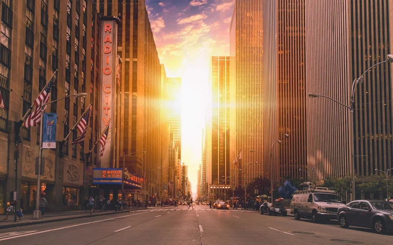 sunset bathed in sunlight between new york city's skyscrapers, cars, automobiles, cities, city, cityscape, cityscapes, evening, evenings, twilight, dus, new york, pedestrians, roads, highways, motorways, avenues, driveways, passageways, skyscrapers, streets, sun, sun rays, sunlight, rays, sunsets, sunset, usa, united states, architecture, world