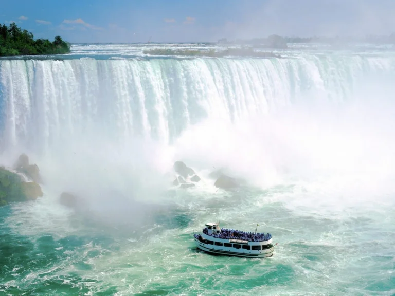 A sightseeing boat in a cloud of spray at the base of Niagara Falls
