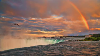 A rainbow over the Niagara Falls in the glow of the sunset